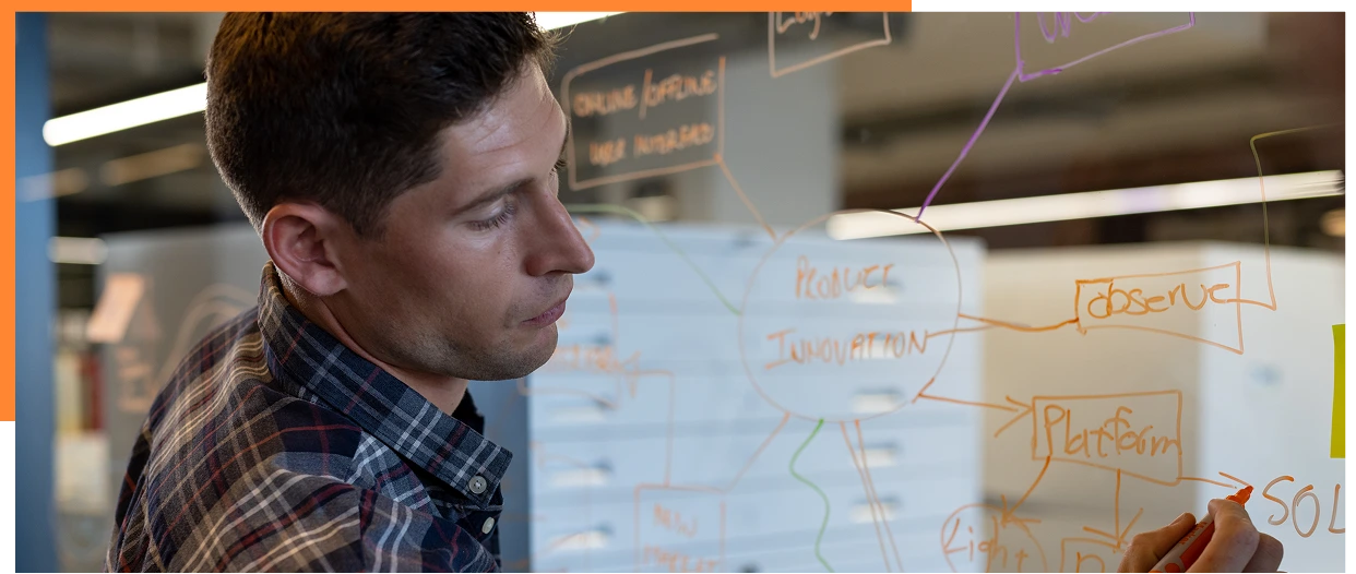 Caucasian casual businessman making notes brainstorming at glass wall in office. Casual office, business, brainstorm and work, unaltered.