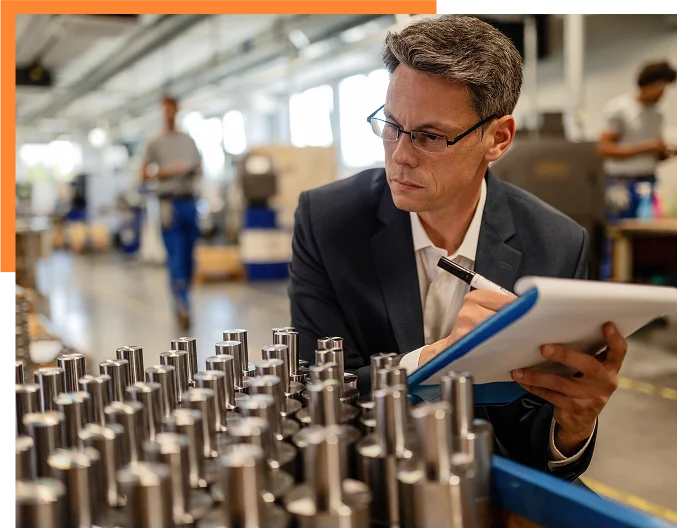Quality control inspector writing reports while analzying manufactured steel rod cylinders in industrial building